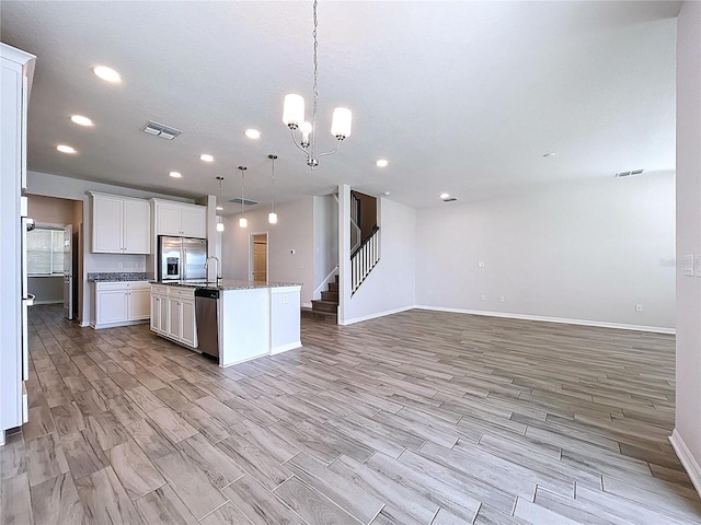 3063 Marine Grass Dr, Wimauma, FL 33598 - kitchen featuring appliances with stainless steel finishes, open floor plan, baseboards, a center island with sink, and recessed lighting