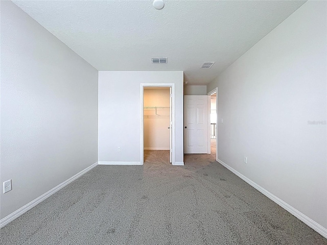 3063 Marine Grass Dr, Wimauma, FL 33598 - unfurnished bedroom featuring baseboards, a spacious closet, carpet flooring, a closet, and a textured ceiling