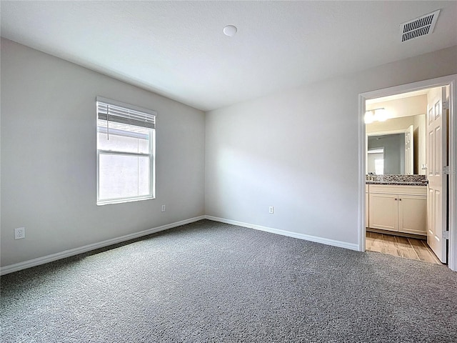 3063 Marine Grass Dr, Wimauma, FL 33598 - unfurnished bedroom featuring light colored carpet, baseboards, and ensuite bathroom