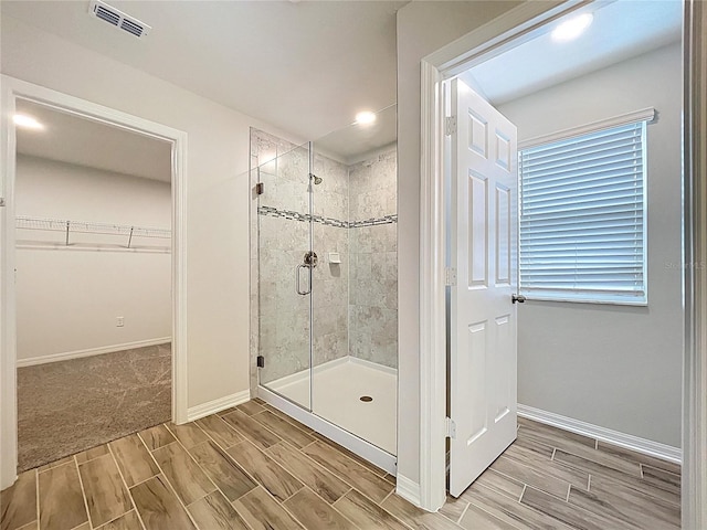 3063 Marine Grass Dr, Wimauma, FL 33598 - bathroom featuring a shower stall, wood tiled floors, a spacious closet, and baseboards