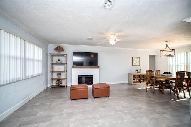 11071 141st St, Largo, FL 33774 - living room with baseboards, a glass covered fireplace, ceiling fan, crown molding, and a chandelier