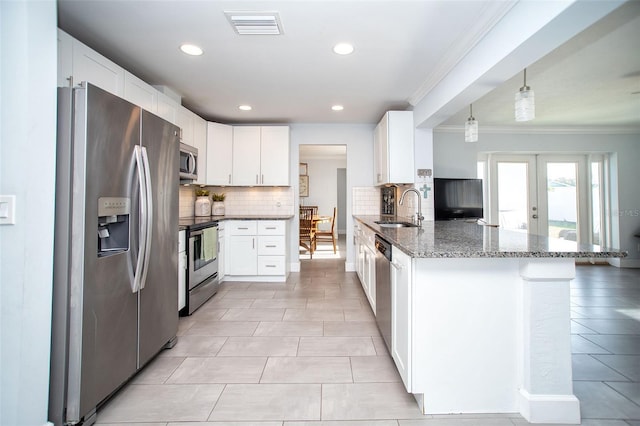 11071 141st St, Largo, FL 33774 - kitchen featuring appliances with stainless steel finishes, a sink, crown molding, a peninsula, and backsplash