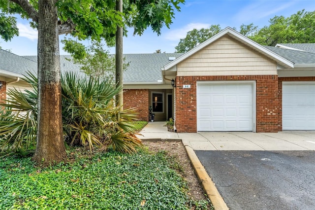 13200 W Newberry Rd Unit B8, Newberry, FL 32669 - view of front of house featuring driveway, brick siding, a garage, and a shingled roof