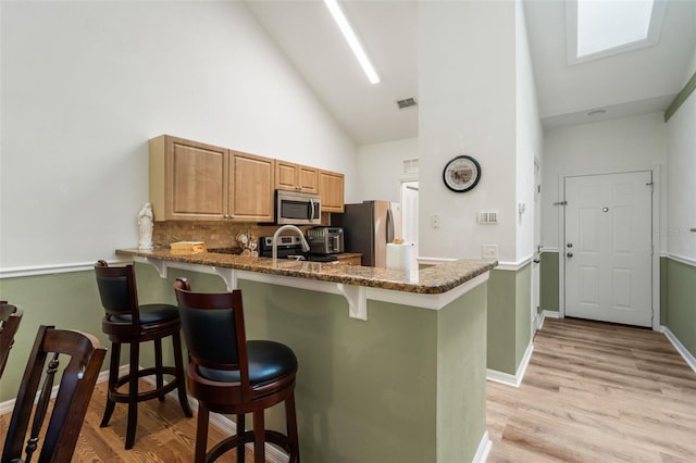 13200 W Newberry Rd Unit B8, Newberry, FL 32669 - kitchen featuring stainless steel appliances, high vaulted ceiling, a kitchen bar, a peninsula, and dark stone countertops
