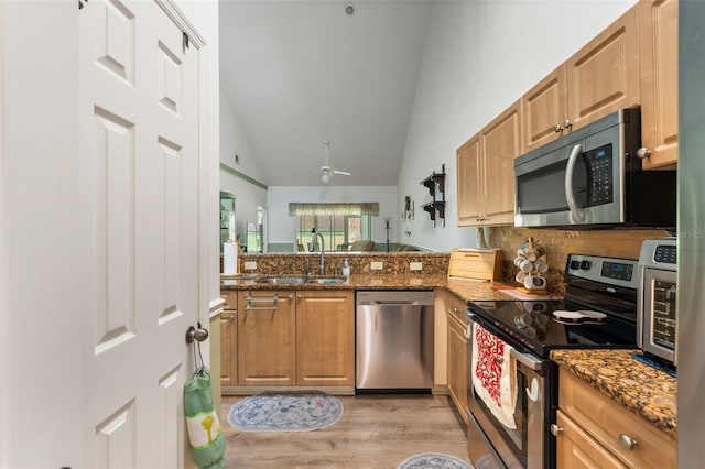 13200 W Newberry Rd Unit B8, Newberry, FL 32669 - kitchen featuring appliances with stainless steel finishes, a sink, vaulted ceiling, light wood-type flooring, and stone counters