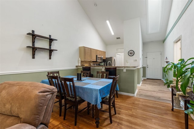 13200 W Newberry Rd Unit B8, Newberry, FL 32669 - dining space featuring high vaulted ceiling, light wood finished floors, and baseboards