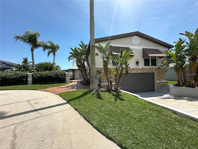 3654 Corsair Ct, New Port Richey, FL 34652 - view of front of home with stone siding, driveway, a front yard, and a garage