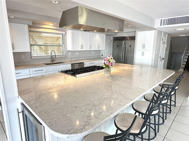3654 Corsair Ct, New Port Richey, FL 34652 - kitchen with stainless steel appliances, a sink, island exhaust hood, light tile patterned floors, and white cabinetry