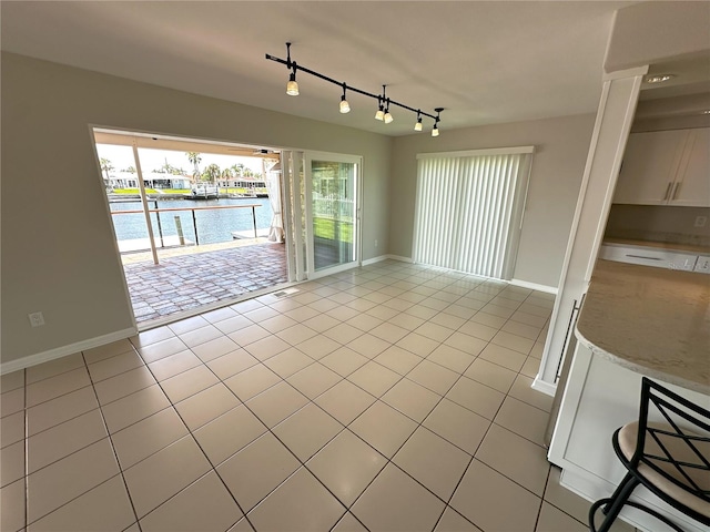 3654 Corsair Ct, New Port Richey, FL 34652 - spare room with a water view, rail lighting, light tile patterned floors, and baseboards