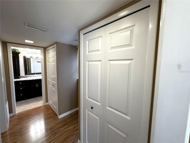 3654 Corsair Ct, New Port Richey, FL 34652 - corridor with light wood finished floors, baseboards, and a sink