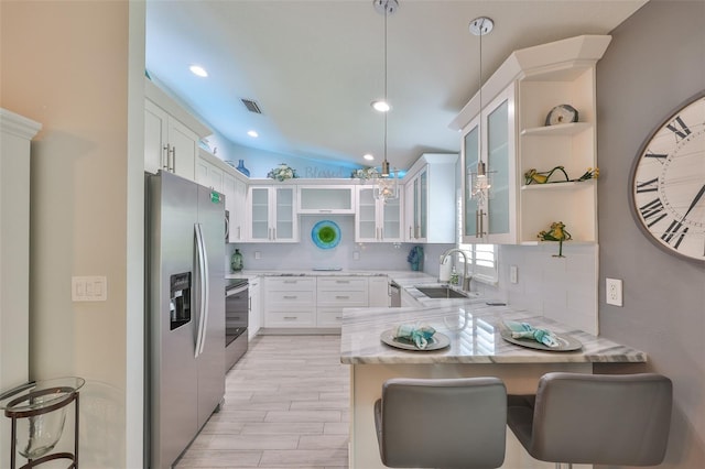 214 Lookout Dr, Apollo Beach, FL 33572 - kitchen with open shelves, stainless steel appliances, a peninsula, tasteful backsplash, and vaulted ceiling