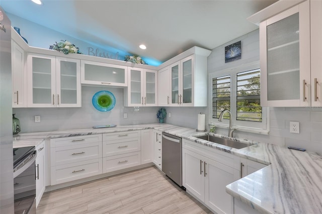 214 Lookout Dr, Apollo Beach, FL 33572 - kitchen with stainless steel appliances, a sink, backsplash, white cabinets, and lofted ceiling