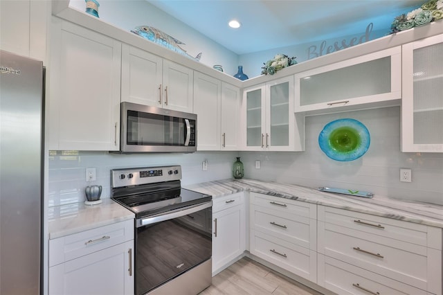 214 Lookout Dr, Apollo Beach, FL 33572 - kitchen featuring stainless steel appliances, white cabinets, decorative backsplash, and recessed lighting