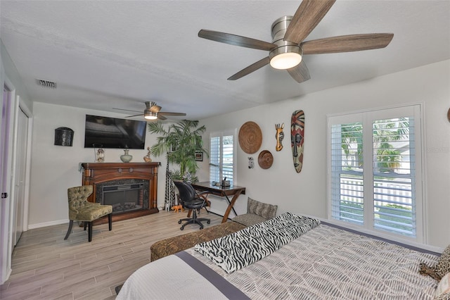 214 Lookout Dr, Apollo Beach, FL 33572 - bedroom with multiple windows, light wood-style floors, a high end fireplace, and a ceiling fan