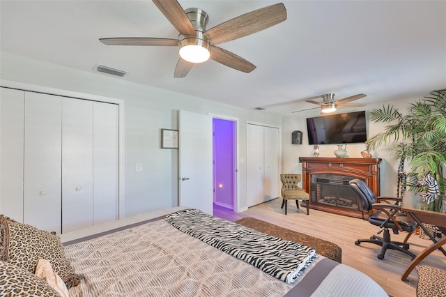214 Lookout Dr, Apollo Beach, FL 33572 - bedroom with a high end fireplace, wood finished floors, ceiling fan, and multiple closets