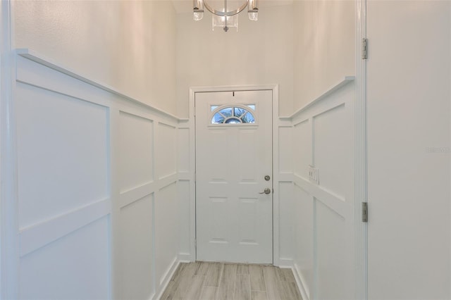 214 Lookout Dr, Apollo Beach, FL 33572 - doorway with a decorative wall, light wood finished floors, and a chandelier