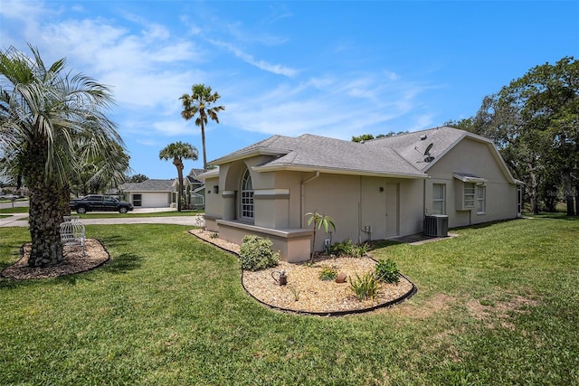 14181 Cornewall Ln, Spring Hill, FL 34609 - view of property exterior with driveway, a lawn, stucco siding, and central AC unit
