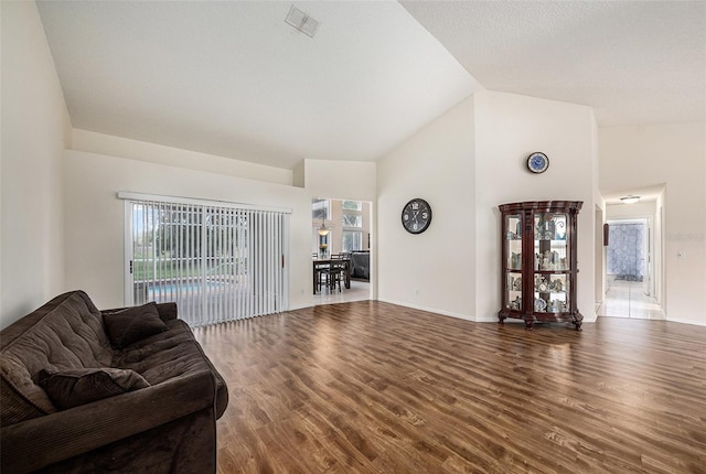 14181 Cornewall Ln, Spring Hill, FL 34609 - living room featuring wood finished floors, baseboards, and high vaulted ceiling