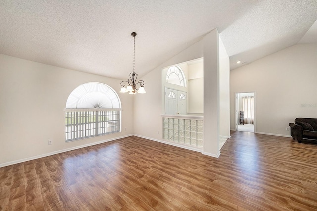 14181 Cornewall Ln, Spring Hill, FL 34609 - unfurnished room featuring a chandelier, wood finished floors, a textured ceiling, baseboards, and high vaulted ceiling