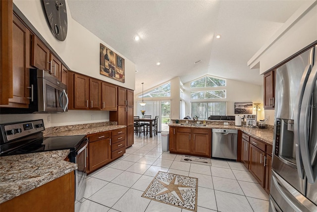14181 Cornewall Ln, Spring Hill, FL 34609 - kitchen with stainless steel appliances, vaulted ceiling, a sink, a peninsula, and light tile patterned floors