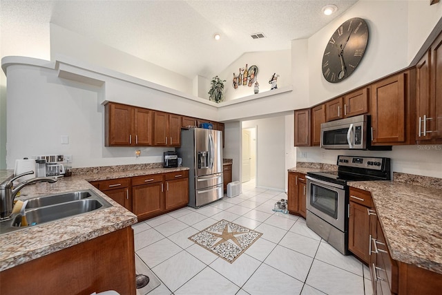 14181 Cornewall Ln, Spring Hill, FL 34609 - kitchen featuring stainless steel appliances, a sink, light tile patterned flooring, high vaulted ceiling, and a textured ceiling