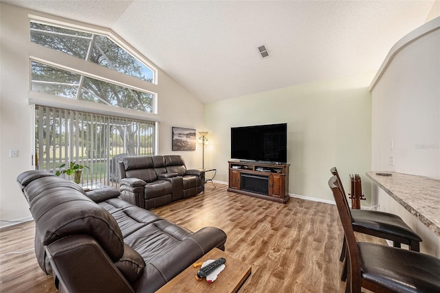 14181 Cornewall Ln, Spring Hill, FL 34609 - living area featuring high vaulted ceiling, light wood-type flooring, and baseboards