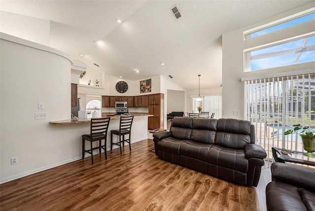 14181 Cornewall Ln, Spring Hill, FL 34609 - living area with high vaulted ceiling, dark wood-style flooring, recessed lighting, and baseboards