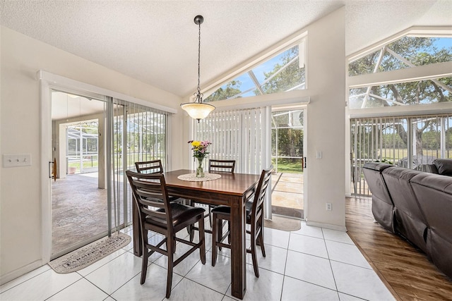 14181 Cornewall Ln, Spring Hill, FL 34609 - dining space with vaulted ceiling, a textured ceiling, baseboards, and light tile patterned floors