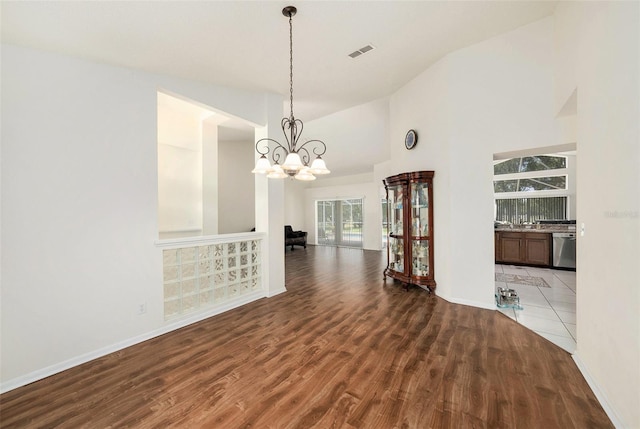 14181 Cornewall Ln, Spring Hill, FL 34609 - unfurnished dining area featuring wood finished floors, a chandelier, baseboards, and high vaulted ceiling