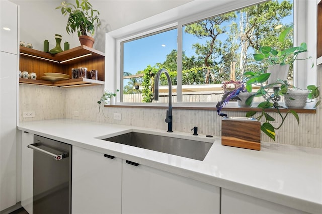 310 55th Ave S, Saint Petersburg, FL 33705 - kitchen with a sink, dishwasher, tasteful backsplash, and white cabinetry