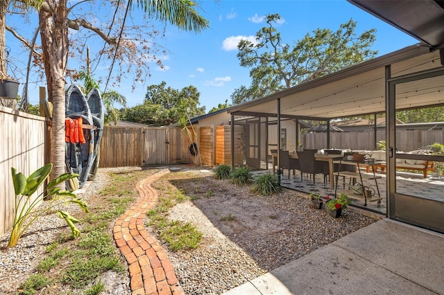 310 55th Ave S, Saint Petersburg, FL 33705 - fenced backyard with a patio area, a gate, and a sunroom
