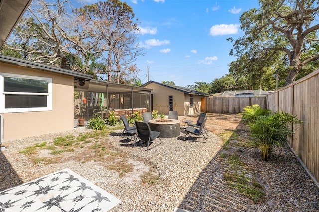 310 55th Ave S, Saint Petersburg, FL 33705 - fenced backyard featuring a sunroom and an outdoor fire pit