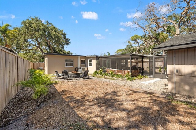 310 55th Ave S, Saint Petersburg, FL 33705 - rear view of house featuring a sunroom and a fire pit