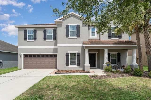 11206 Coventry Grove Cir, Lithia, FL 33547 - view of front of house with stucco siding, an attached garage, driveway, a front lawn, and a porch