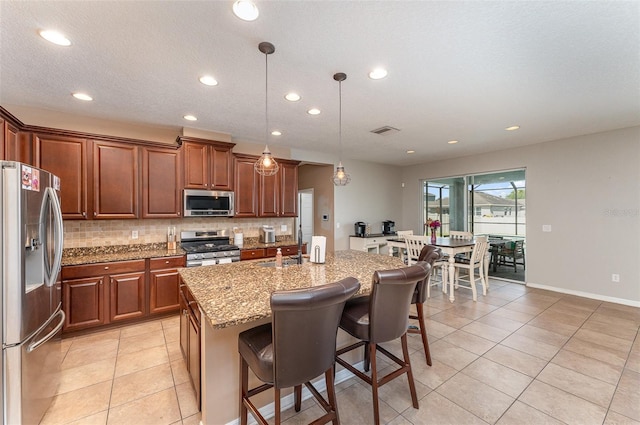11206 Coventry Grove Cir, Lithia, FL 33547 - kitchen featuring stainless steel appliances, recessed lighting, backsplash, light tile patterned flooring, and light stone countertops