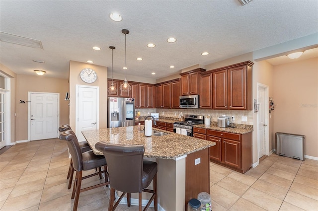 11206 Coventry Grove Cir, Lithia, FL 33547 - kitchen with stainless steel appliances, a sink, decorative backsplash, light stone counters, and a breakfast bar