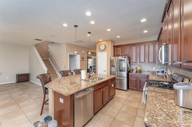 11206 Coventry Grove Cir, Lithia, FL 33547 - kitchen with stainless steel appliances, a sink, a breakfast bar area, light tile patterned floors, and a textured ceiling