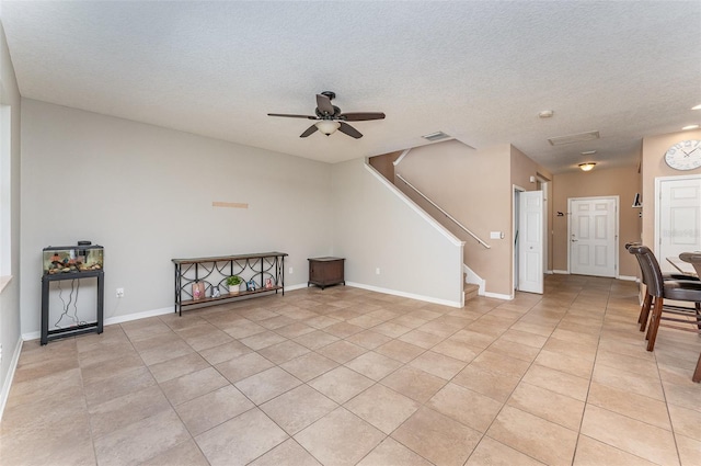 11206 Coventry Grove Cir, Lithia, FL 33547 - unfurnished living room with a ceiling fan, light tile patterned floors, stairs, a textured ceiling, and baseboards