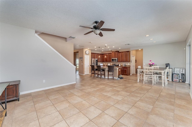 11206 Coventry Grove Cir, Lithia, FL 33547 - kitchen with stainless steel appliances, a breakfast bar, a ceiling fan, a center island, and recessed lighting