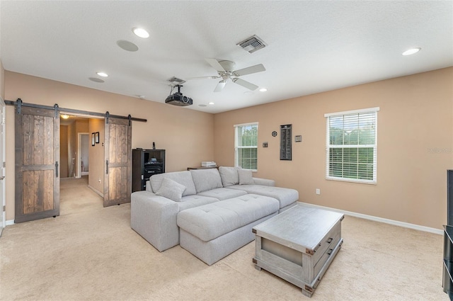 11206 Coventry Grove Cir, Lithia, FL 33547 - living area with a barn door, light colored carpet, ceiling fan, recessed lighting, and baseboards