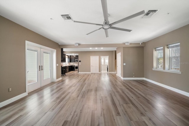 215 18th Ave, Indian Rocks Beach, FL 33785 - unfurnished living room with ceiling fan, light wood-style floors, and french doors