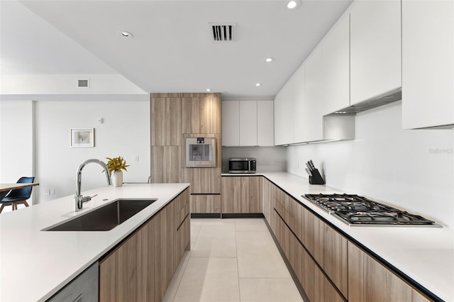 1020 Sunset Point Rd Unit 410, Clearwater, FL 33756 - kitchen with a sink, stainless steel appliances, modern cabinets, under cabinet range hood, and light countertops