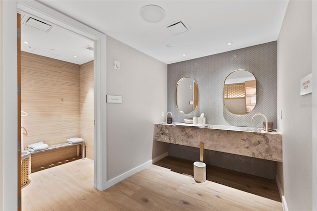 1020 Sunset Point Rd Unit 410, Clearwater, FL 33756 - bathroom featuring wood finished floors, baseboards, and an accent wall