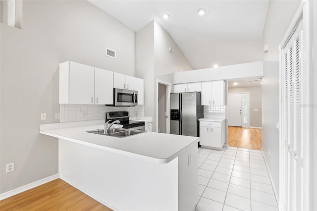 9721 Fredericksburg Rd, Tampa, FL 33635 - kitchen with appliances with stainless steel finishes, light countertops, high vaulted ceiling, a peninsula, and tasteful backsplash
