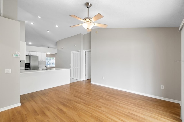 9721 Fredericksburg Rd, Tampa, FL 33635 - unfurnished living room featuring a sink, ceiling fan, light wood-style flooring, high vaulted ceiling, and baseboards