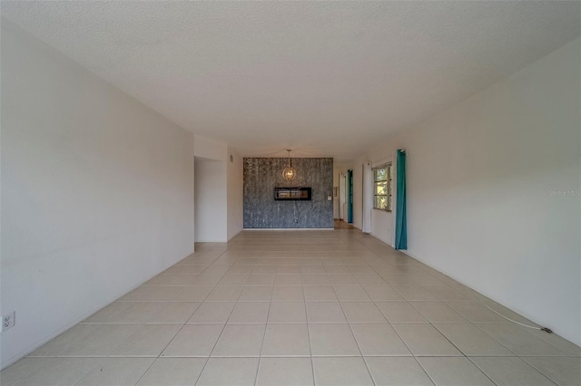 2441 Persian Dr Unit 61, Clearwater, FL 33763 - unfurnished living room with a fireplace, light tile patterned floors, and a textured ceiling