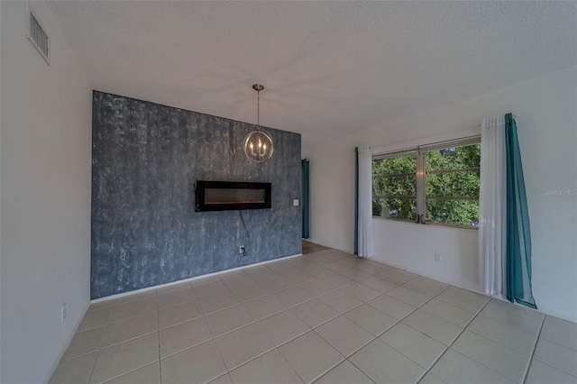 2441 Persian Dr Unit 61, Clearwater, FL 33763 - unfurnished living room featuring a chandelier, an accent wall, a textured ceiling, and tile patterned floors