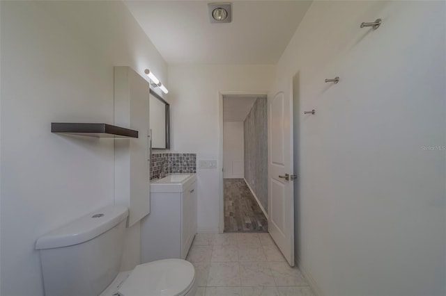 2441 Persian Dr Unit 61, Clearwater, FL 33763 - bathroom with toilet, vanity, marble finish floors, and decorative backsplash