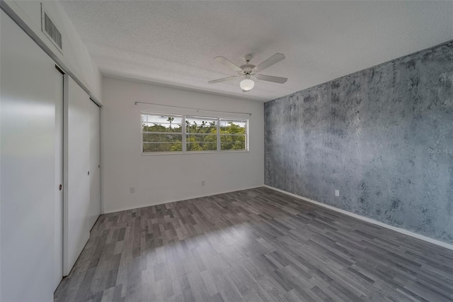 2441 Persian Dr Unit 61, Clearwater, FL 33763 - unfurnished bedroom featuring wood finished floors, a textured ceiling, a ceiling fan, a closet, and baseboards