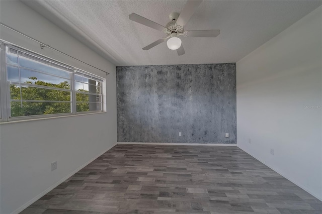 2441 Persian Dr Unit 61, Clearwater, FL 33763 - unfurnished room with an accent wall, wood finished floors, a ceiling fan, baseboards, and a textured ceiling